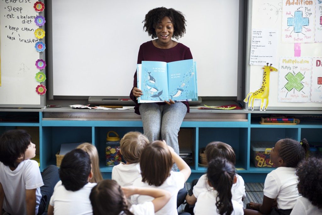 teacher reading a book to her class