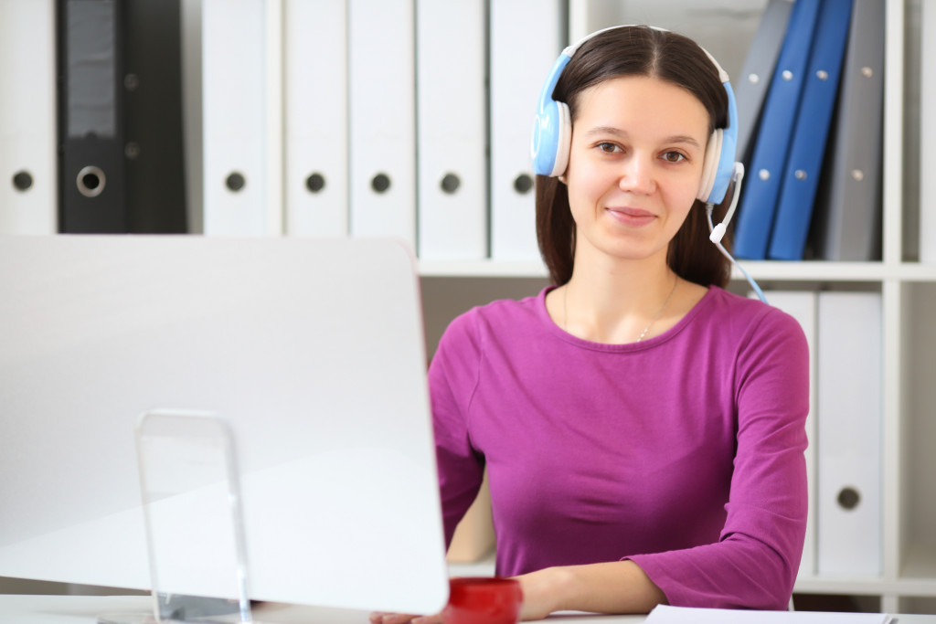 woman infront of desktop with headphones