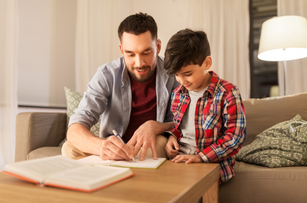 Happy father and son with book writing