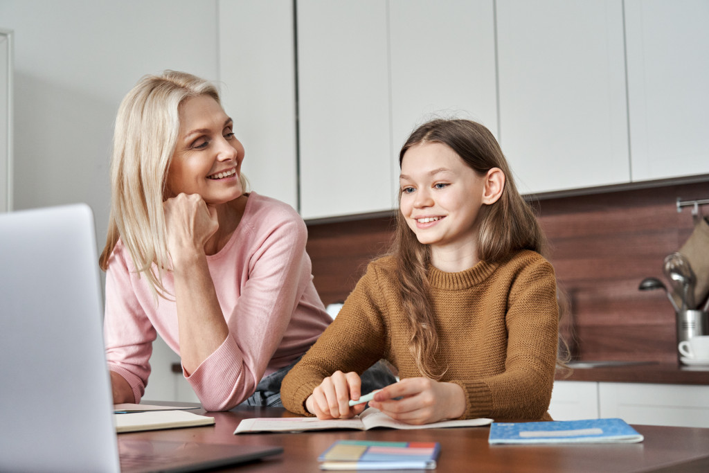 A mother helping her daughter set goals while sitting at a table