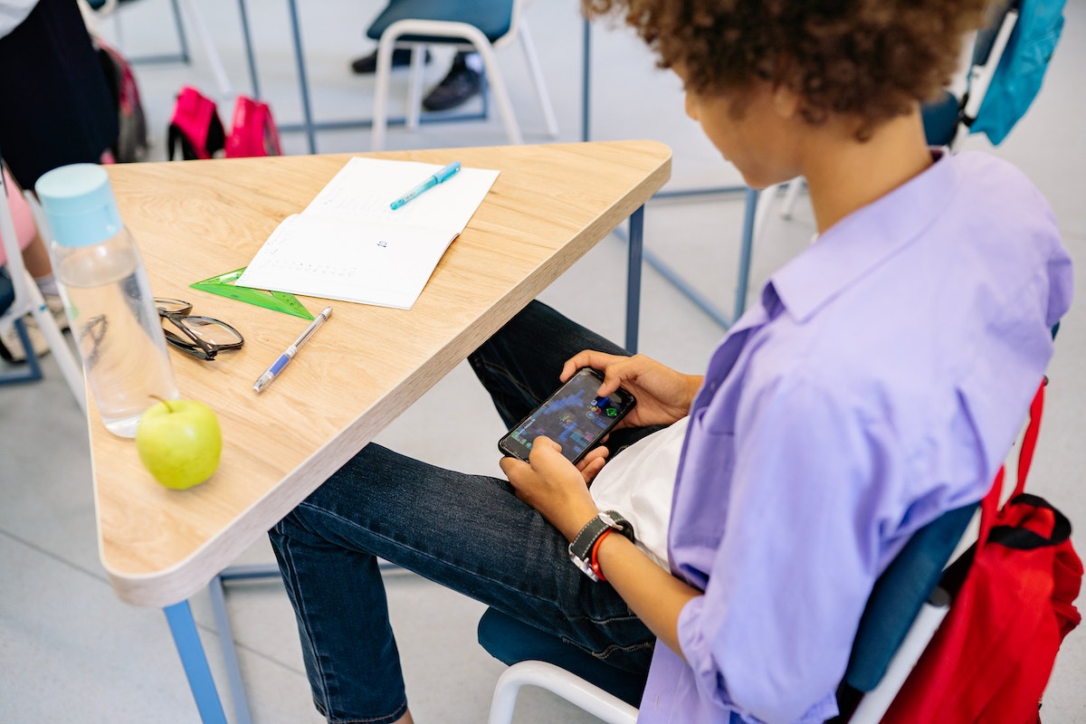 student playing on his phone while in class