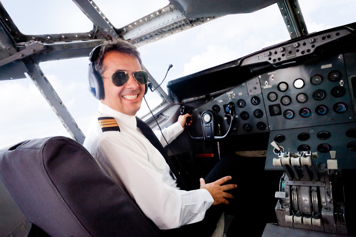 a pilot smiling and flying the plane